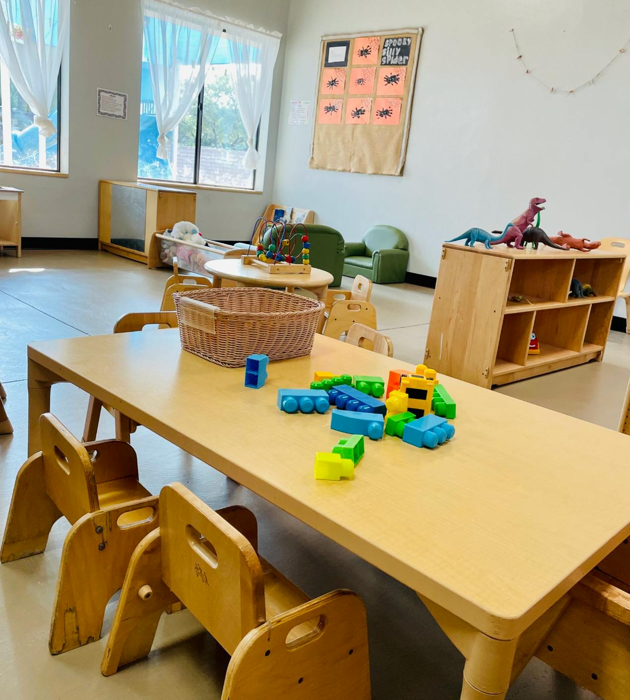 Classroom with small tables and chairs, toys on a table