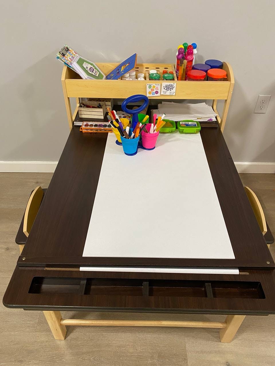 Child's art desk with paper, markers, and art supplies
