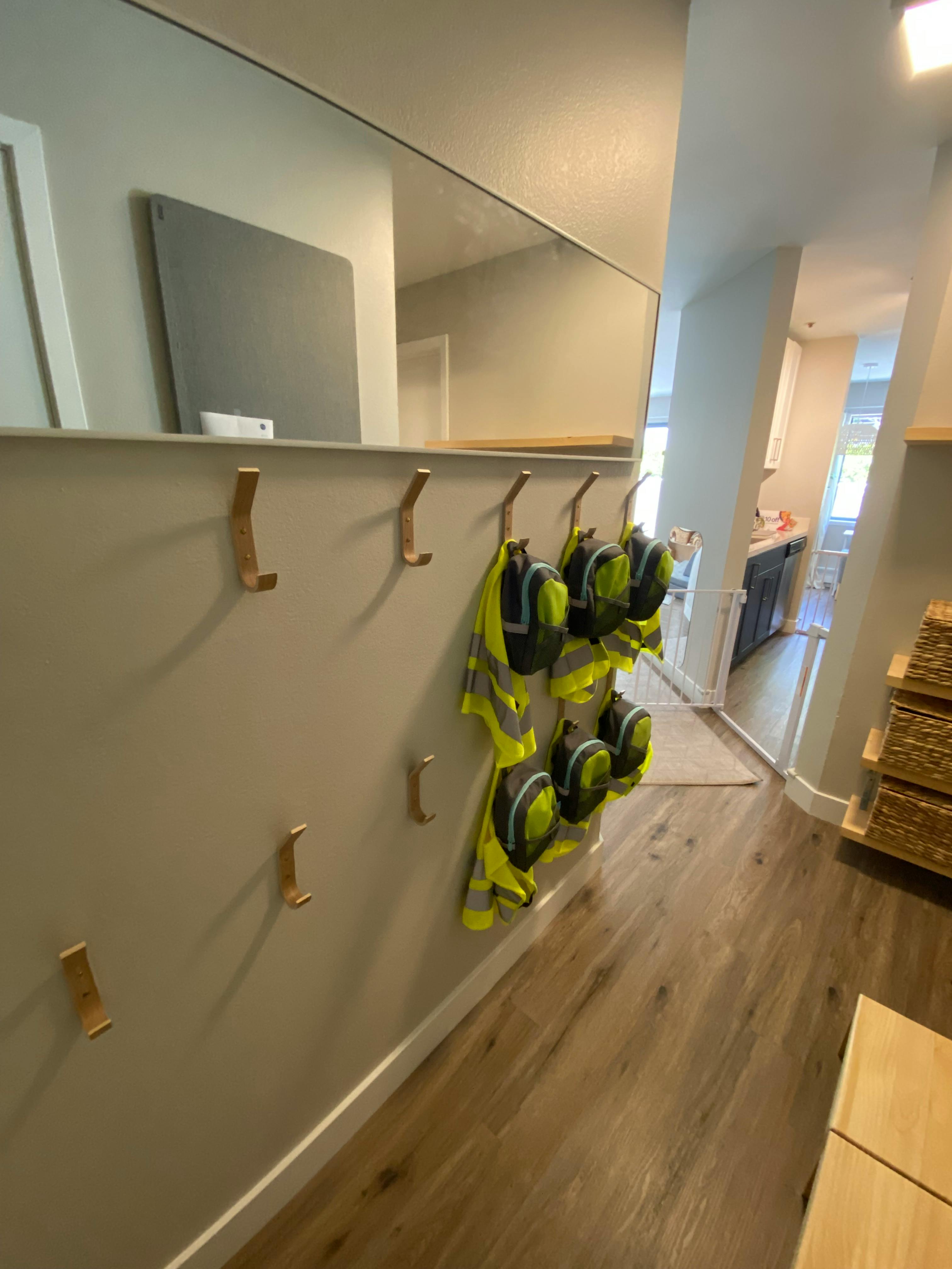 Hallway with coat hooks and high-visibility vests hanging on a wall