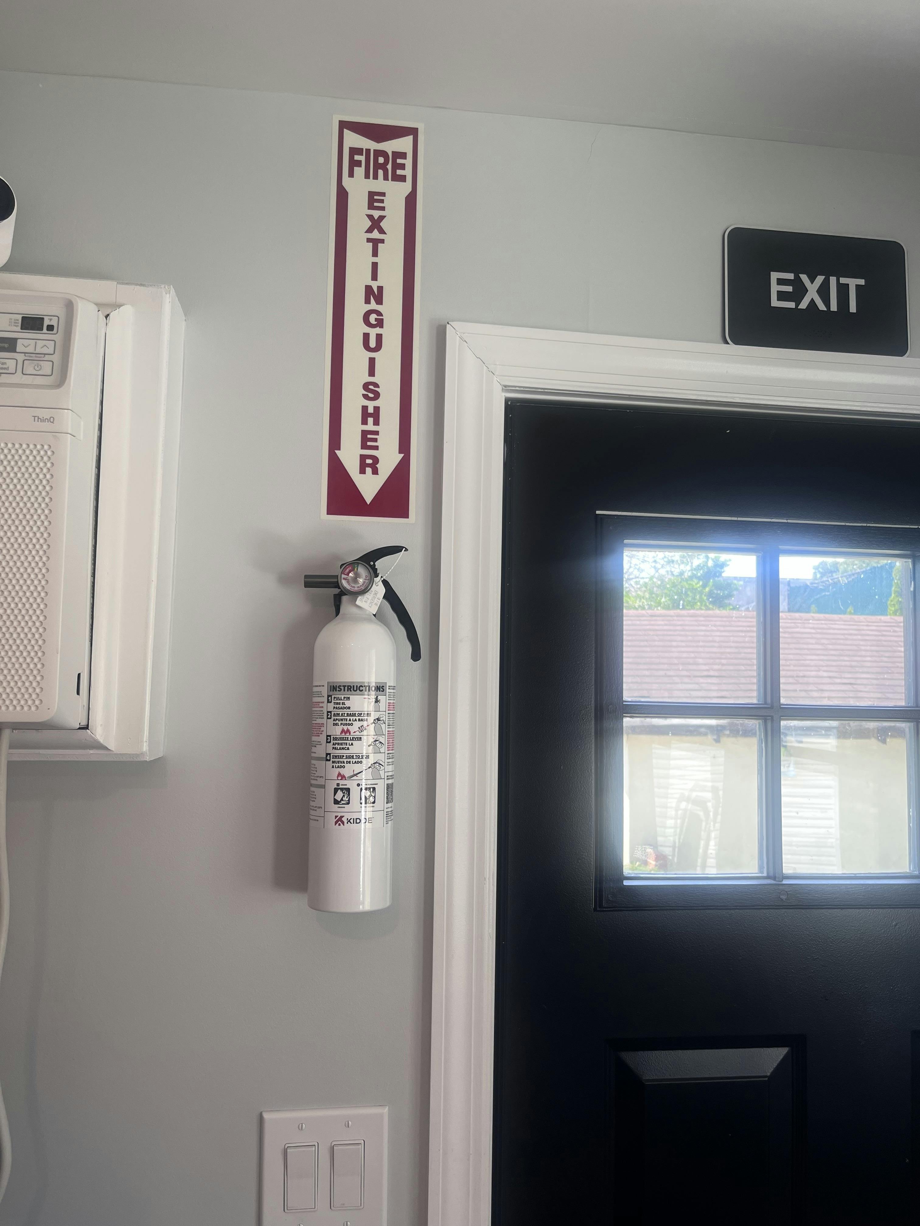Fire extinguisher mounted on a wall next to an exit door
