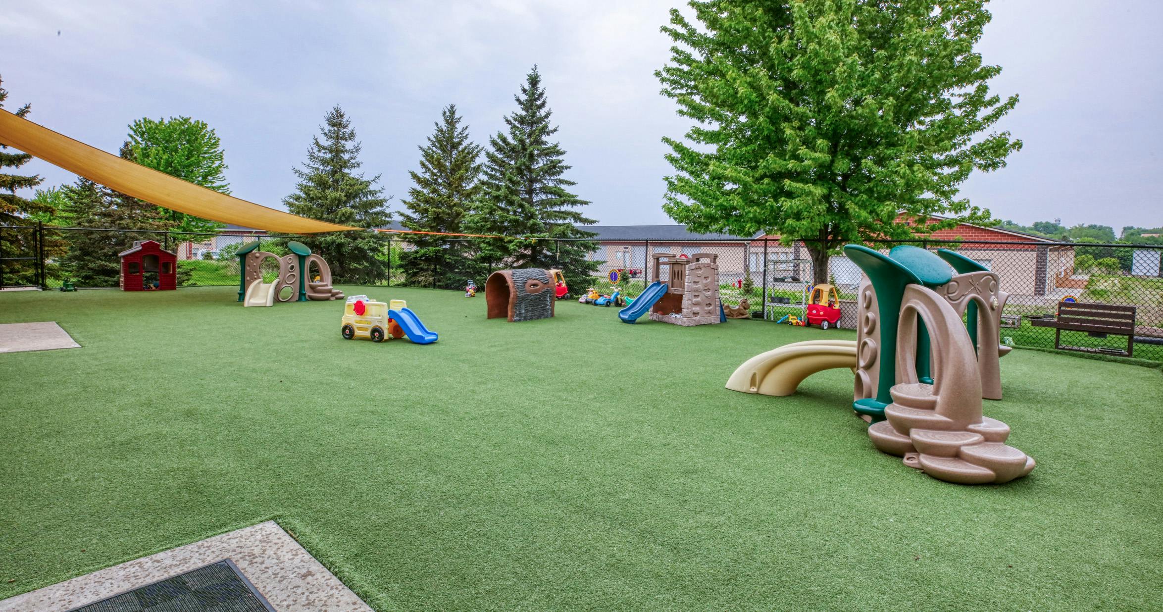 Outdoor playground with artificial turf and various colorful play structures