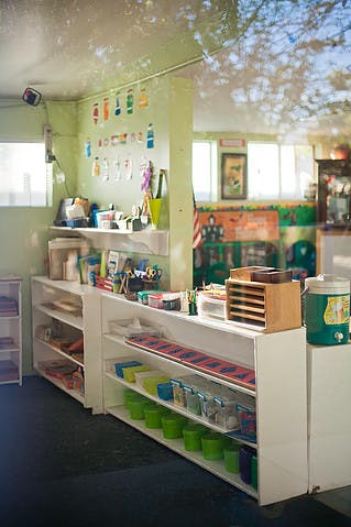 Classroom with shelves of supplies and artwork on the wall