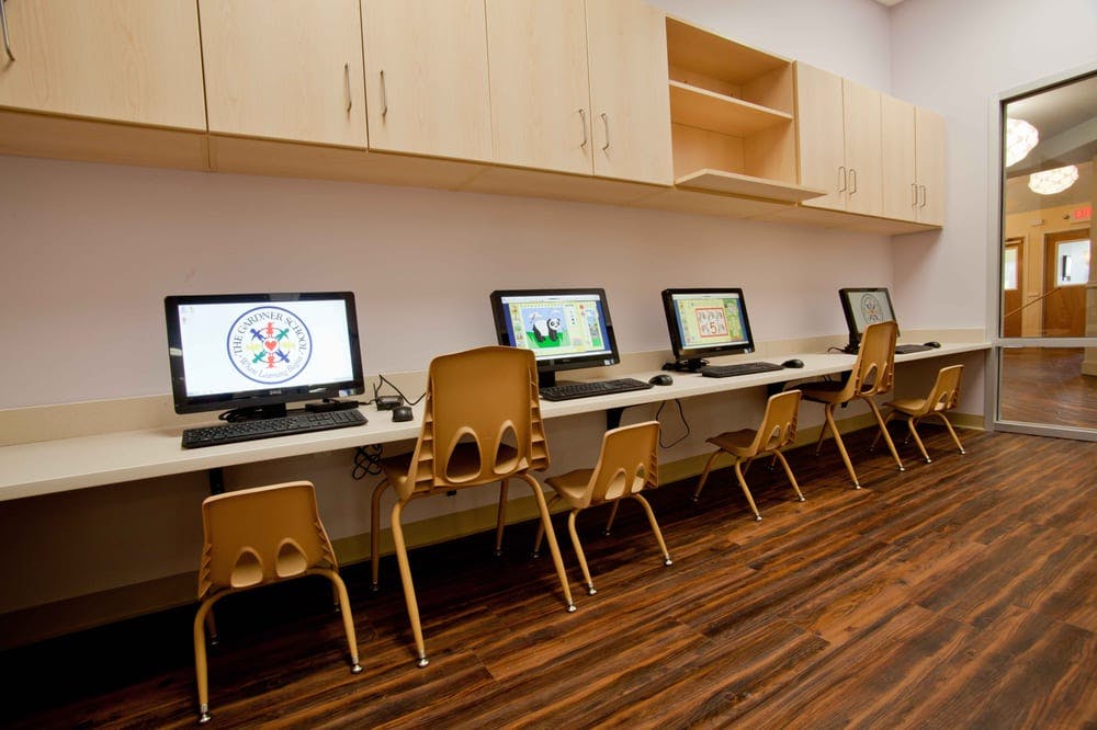 Computer lab with multiple desktop computers and chairs