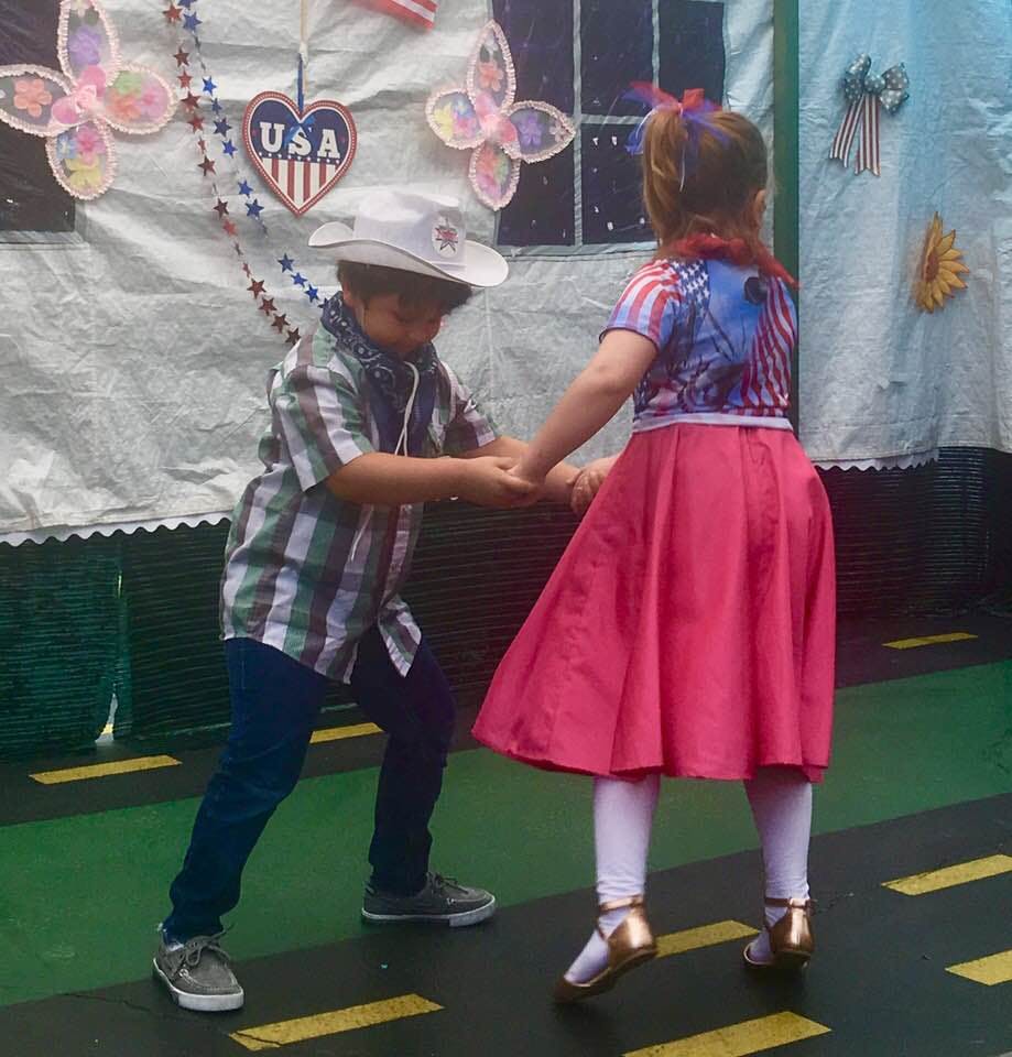 Two children holding hands and dancing