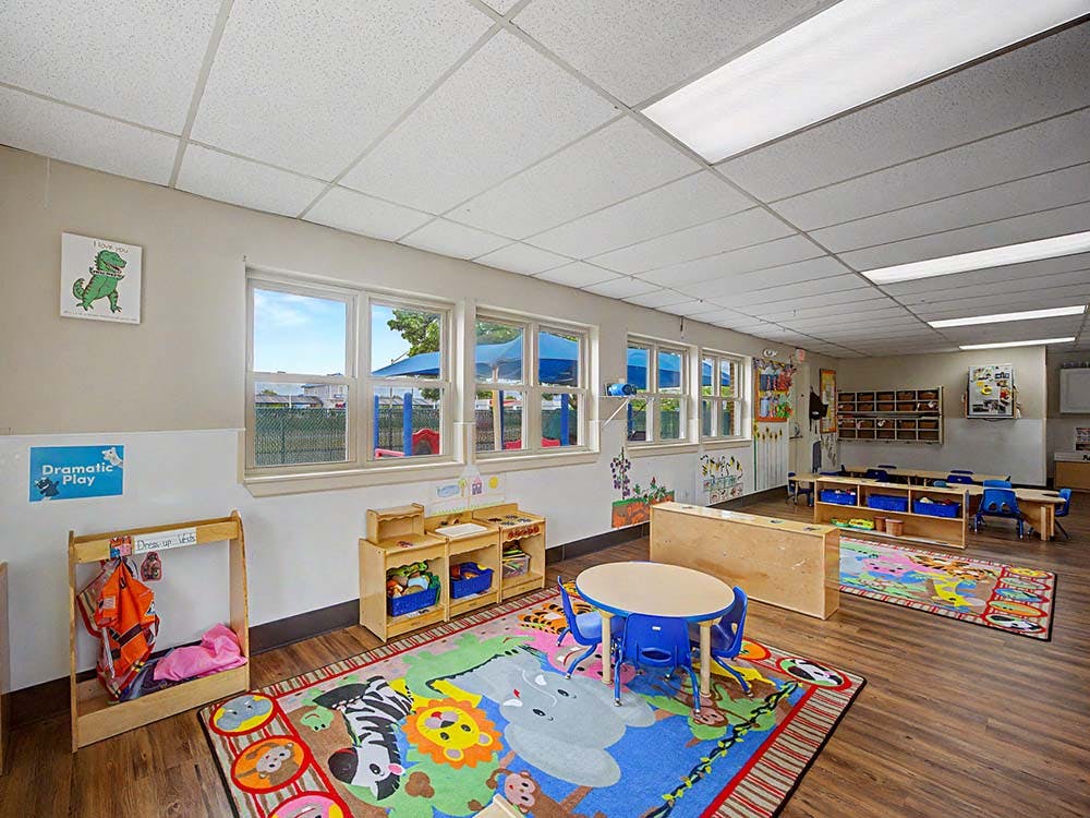 Classroom with child-sized furniture and colorful rugs