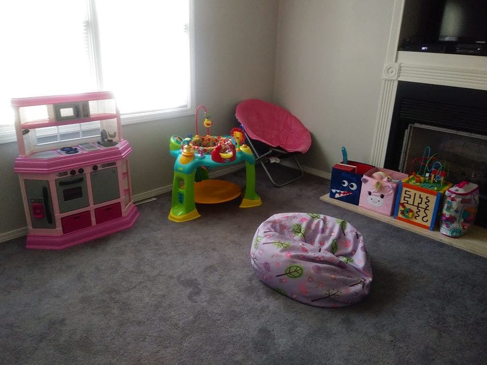 Children's play kitchen, activity table, and toy bins in a room
