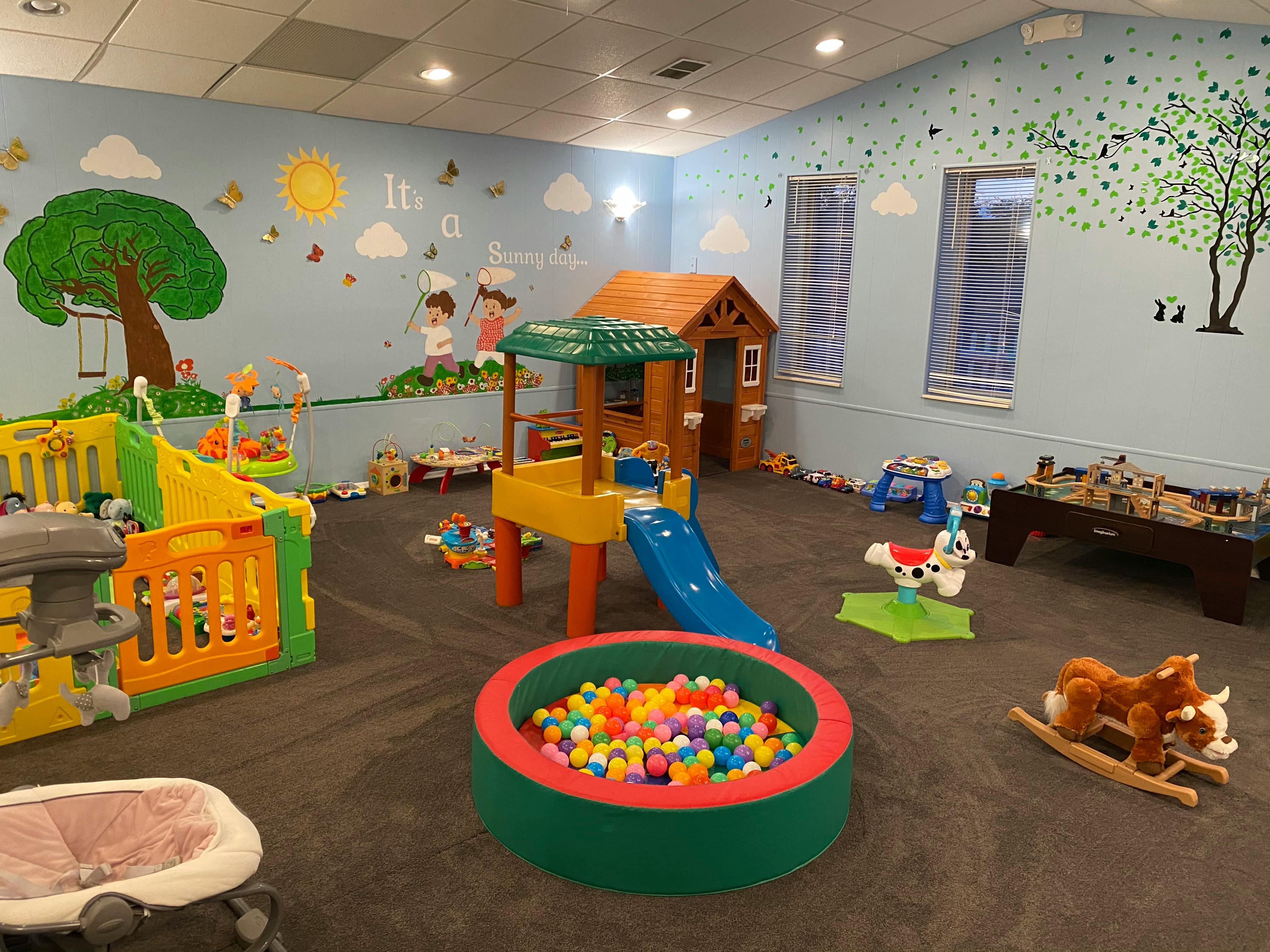 Indoor play area with a ball pit, slide, and playhouses