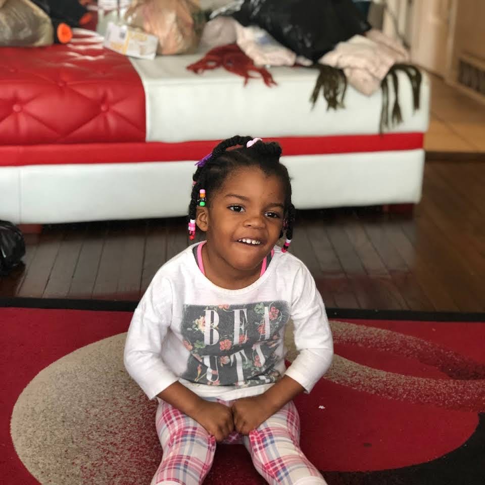 Child sitting on a red rug