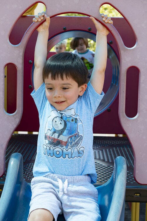 Child holding onto a playground structure