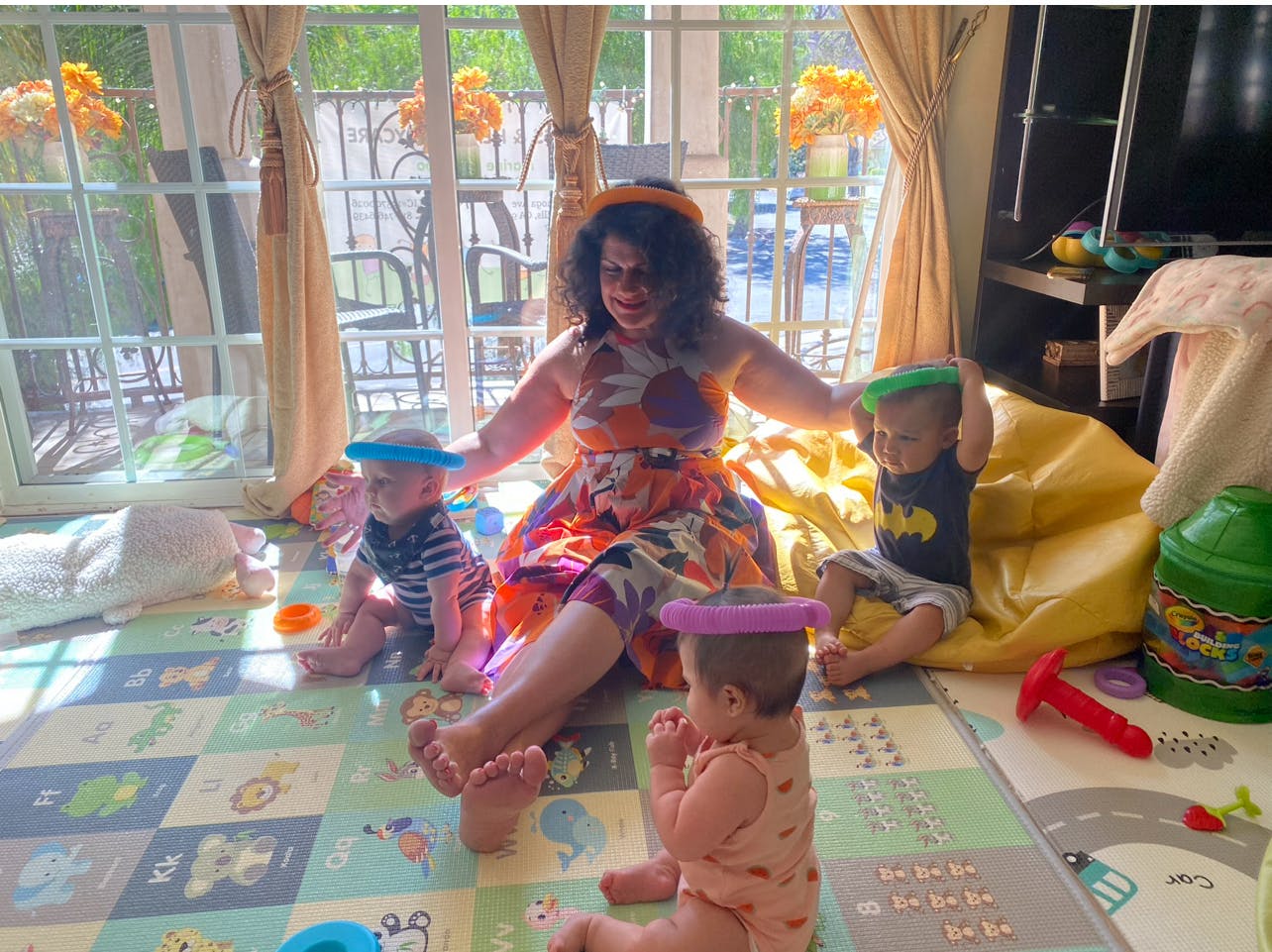 Person sitting on floor with three children