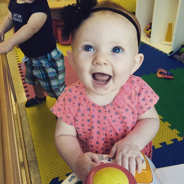 Child in pink shirt playing with a toy