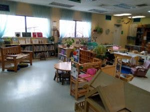 Classroom with small tables, chairs, and bookshelves