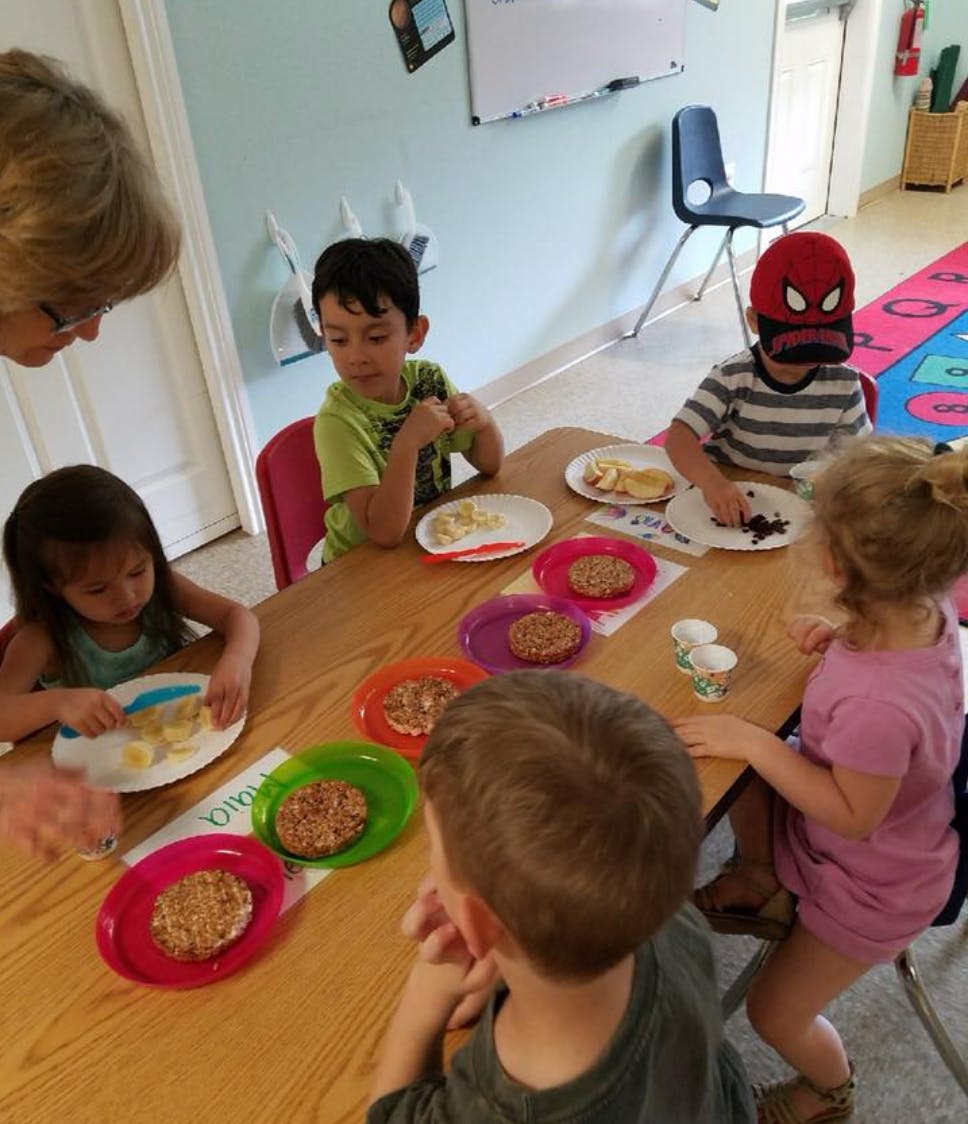 Adult and children sitting at a table with plates of food