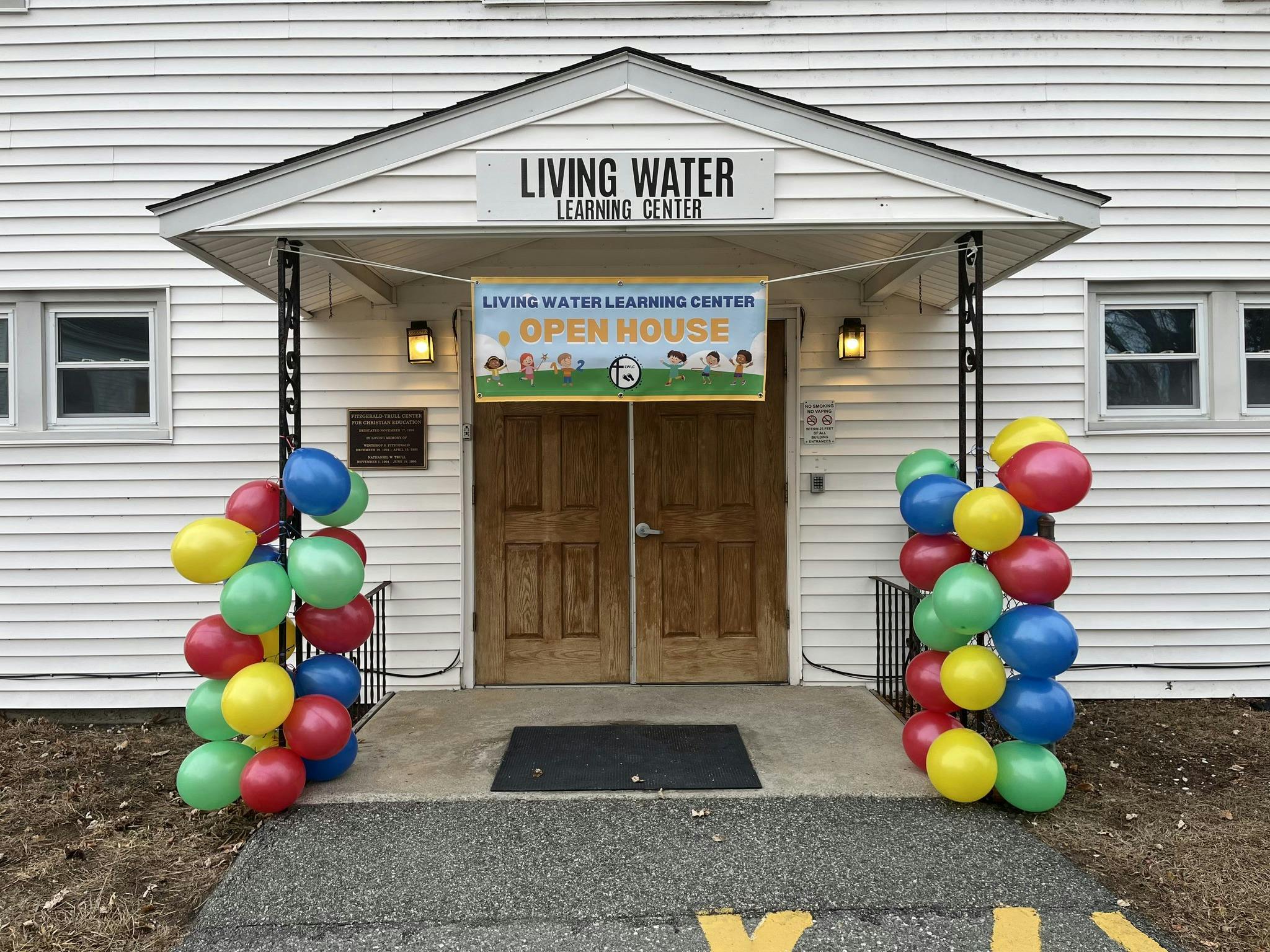 Building entrance with balloons and an "Open House" banner
