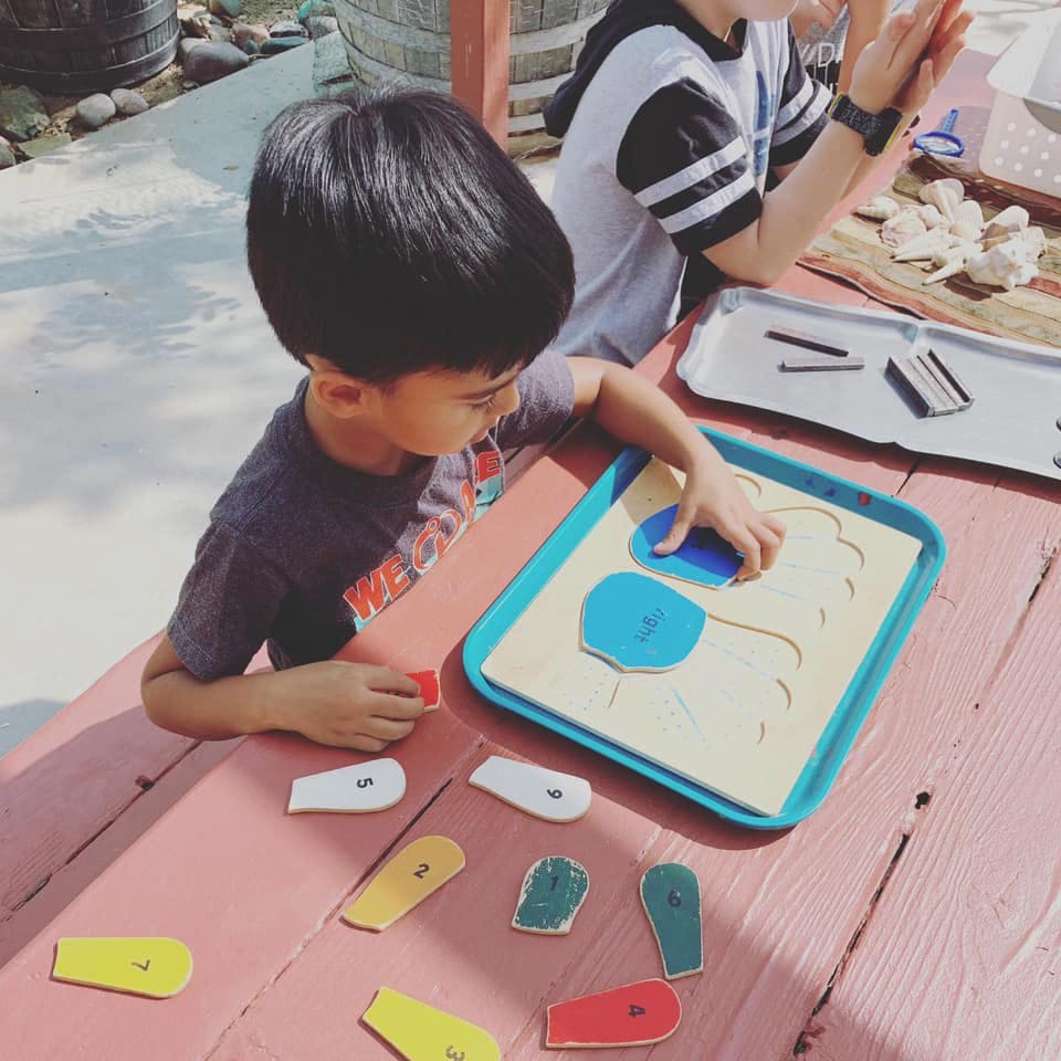 Child playing with a shape puzzle on a wooden table