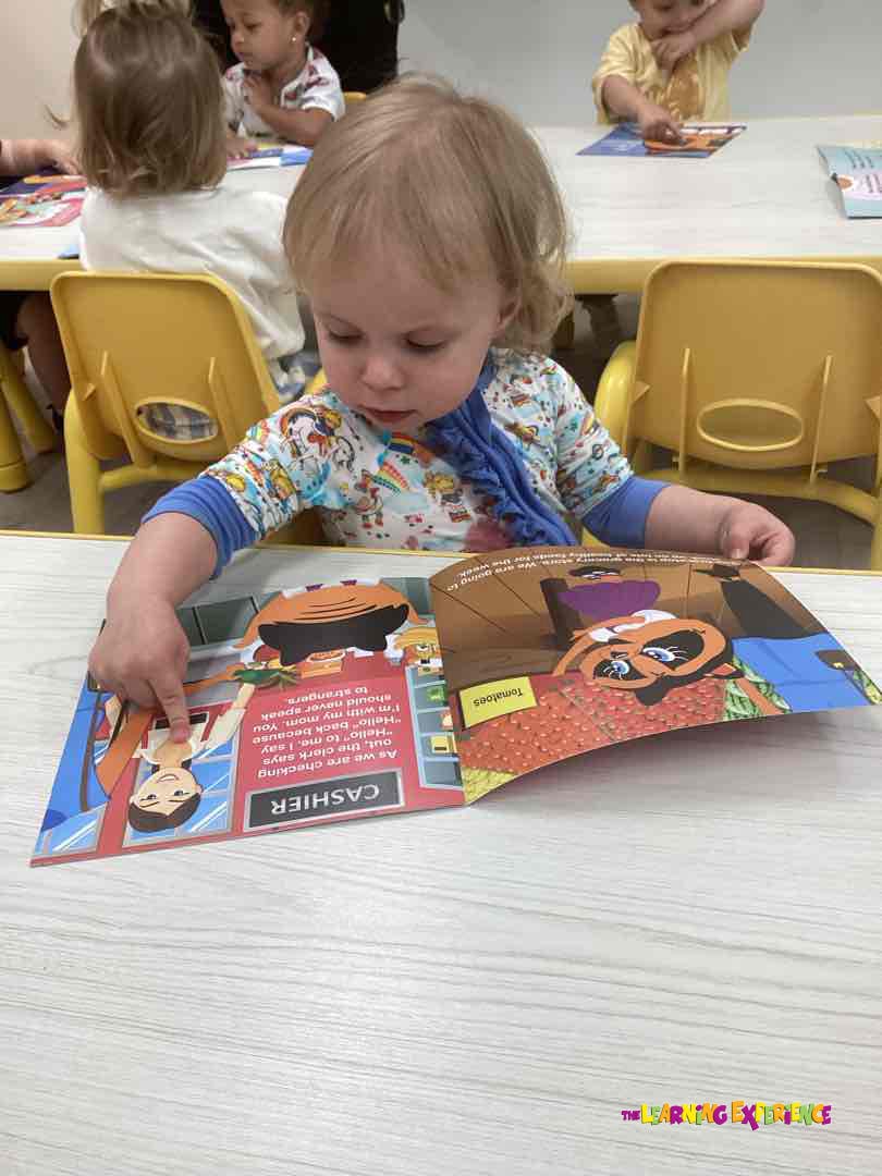Child looking at an open book with text about a cashier