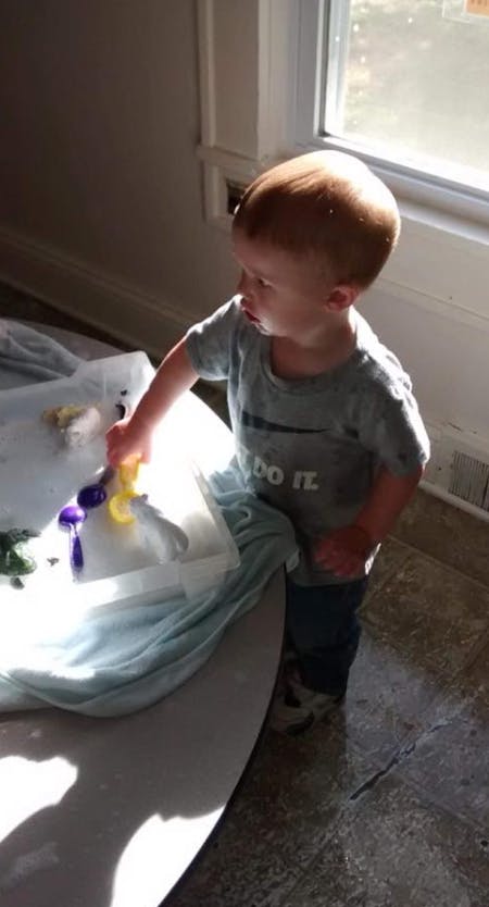 Child playing with toys in a container