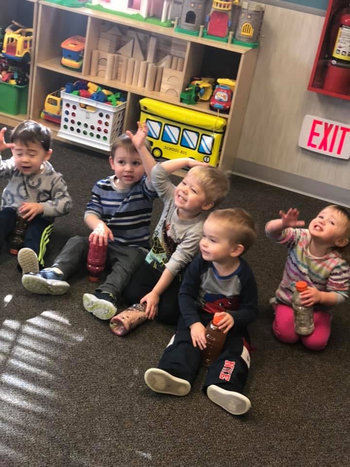 Five children sitting on the floor in a classroom