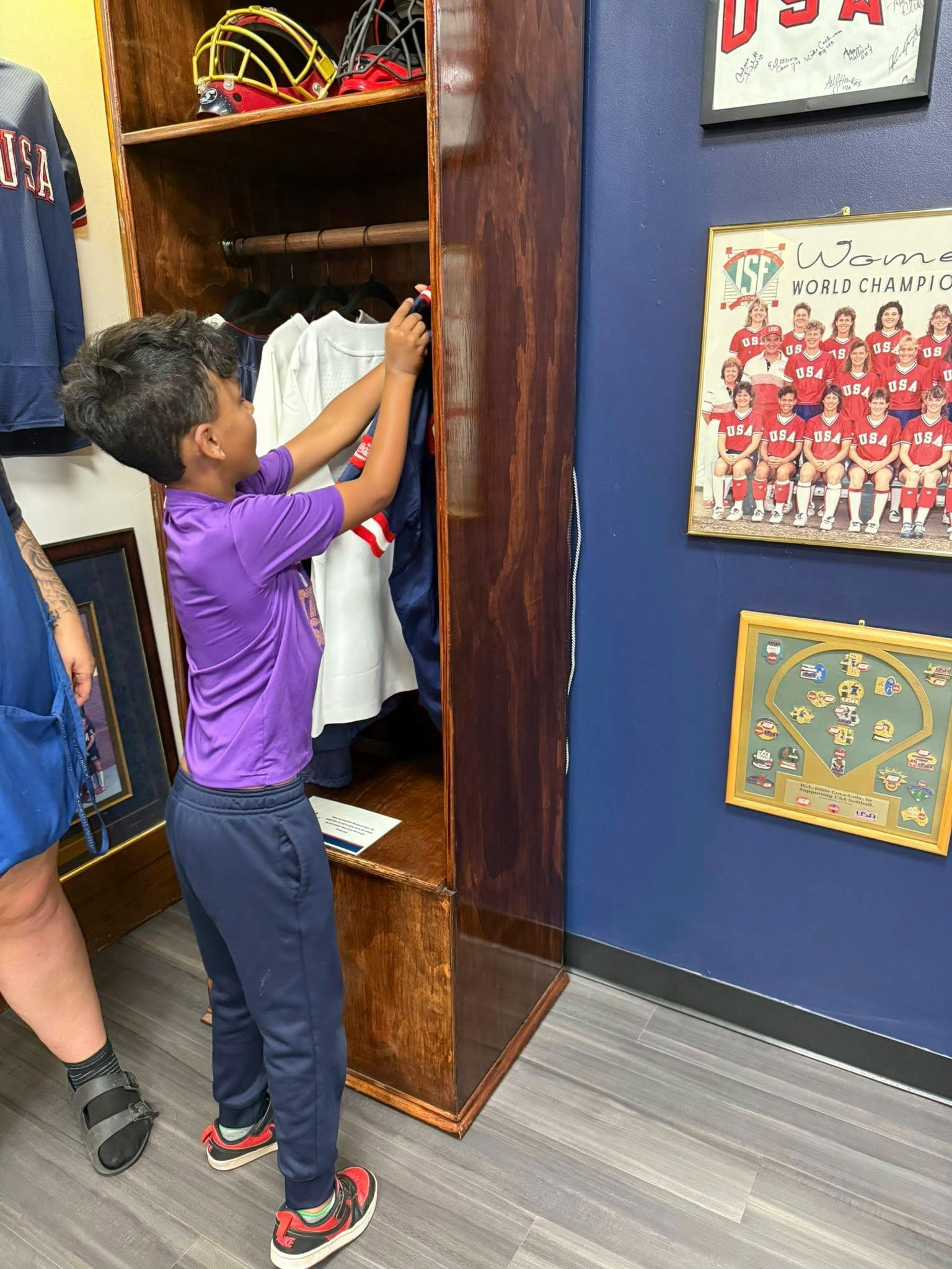 Child reaching into a wooden locker