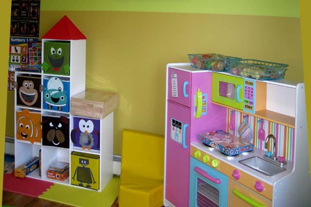 Toy storage unit with character bins and a toy kitchen set