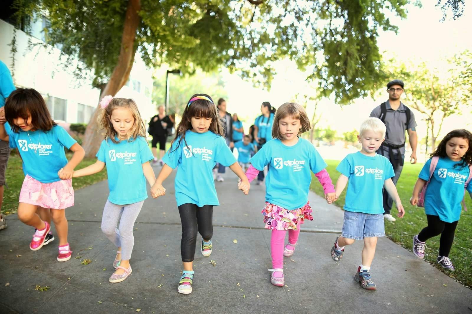 Group of children holding hands and walking outdoors