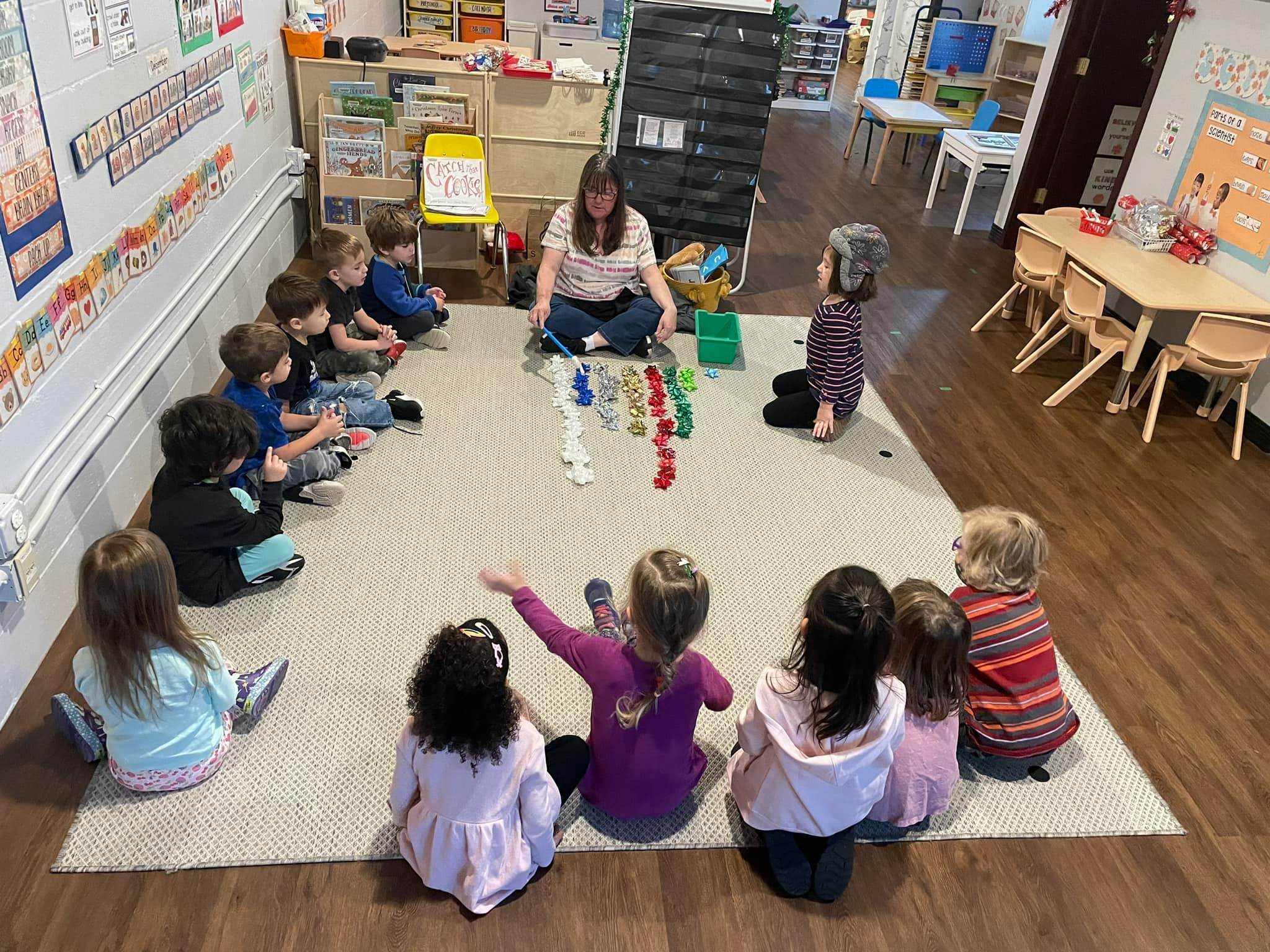 Adult and children sitting on a rug in a classroom
