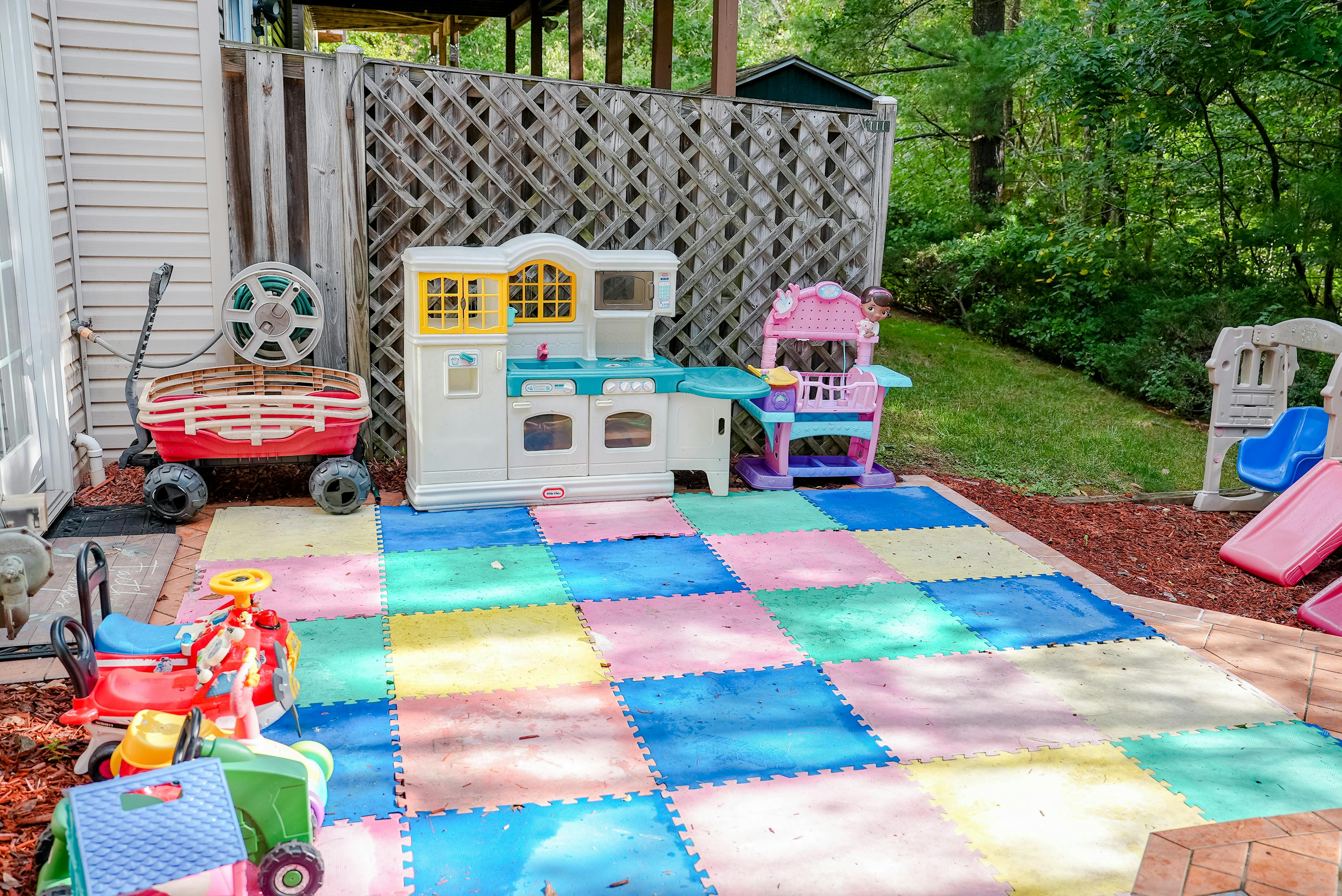Outdoor play area with colorful foam mats and various toys