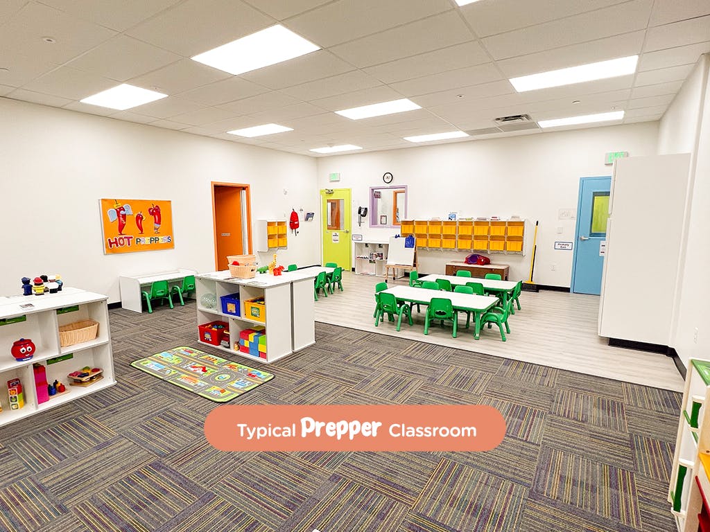 Classroom with small tables and chairs, storage shelves, and colorful decorations