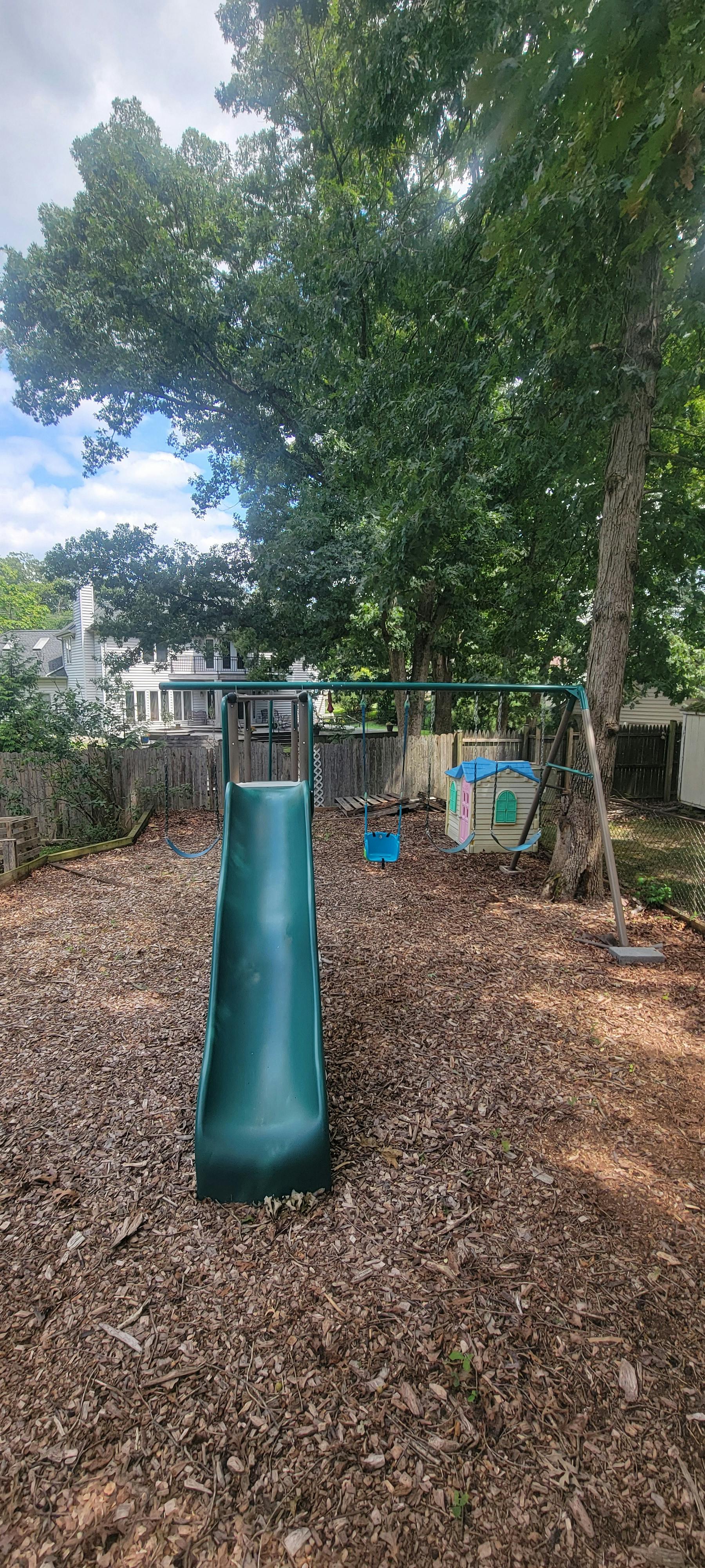 Backyard playground equipment with a slide and swings