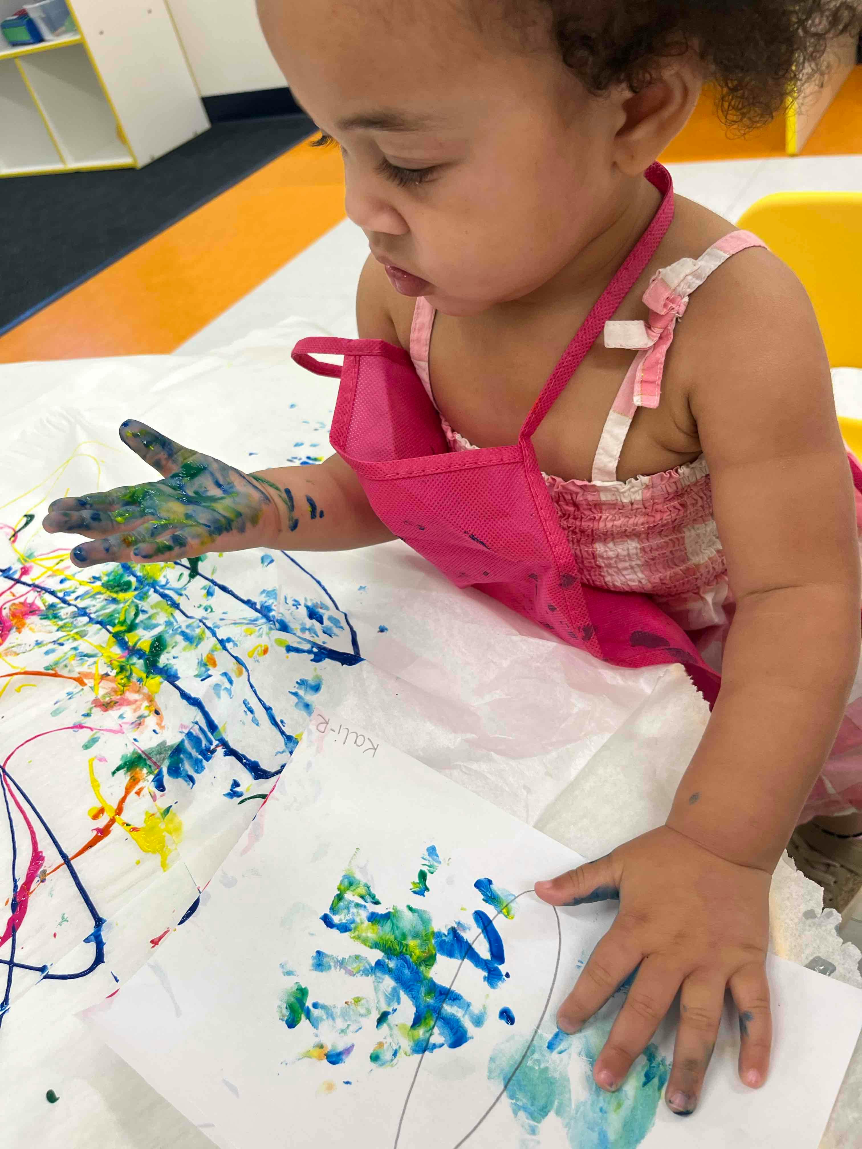 Child with paint on hand making art