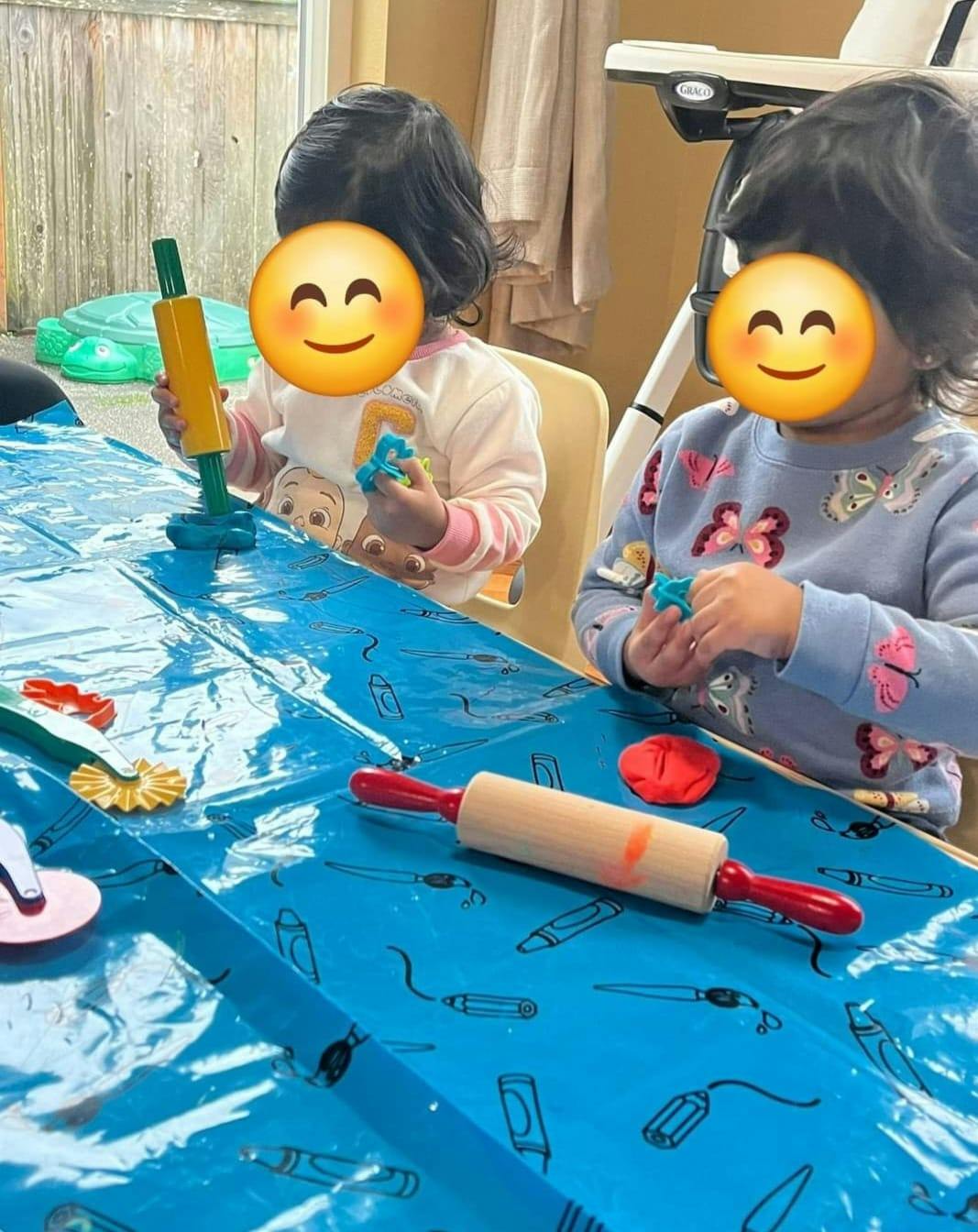 Two children playing with modeling clay and tools at a table