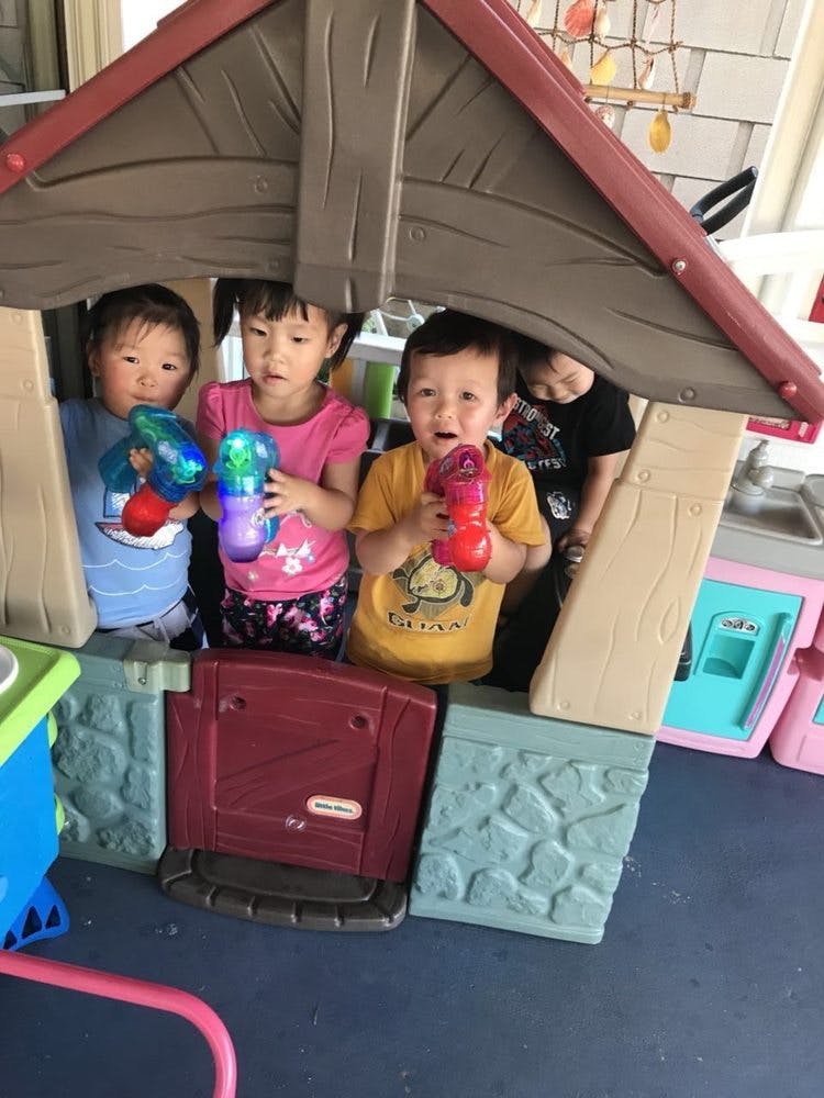 Three children playing in a toy house with light-up toys