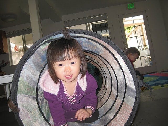 Child crawling out of a play tunnel