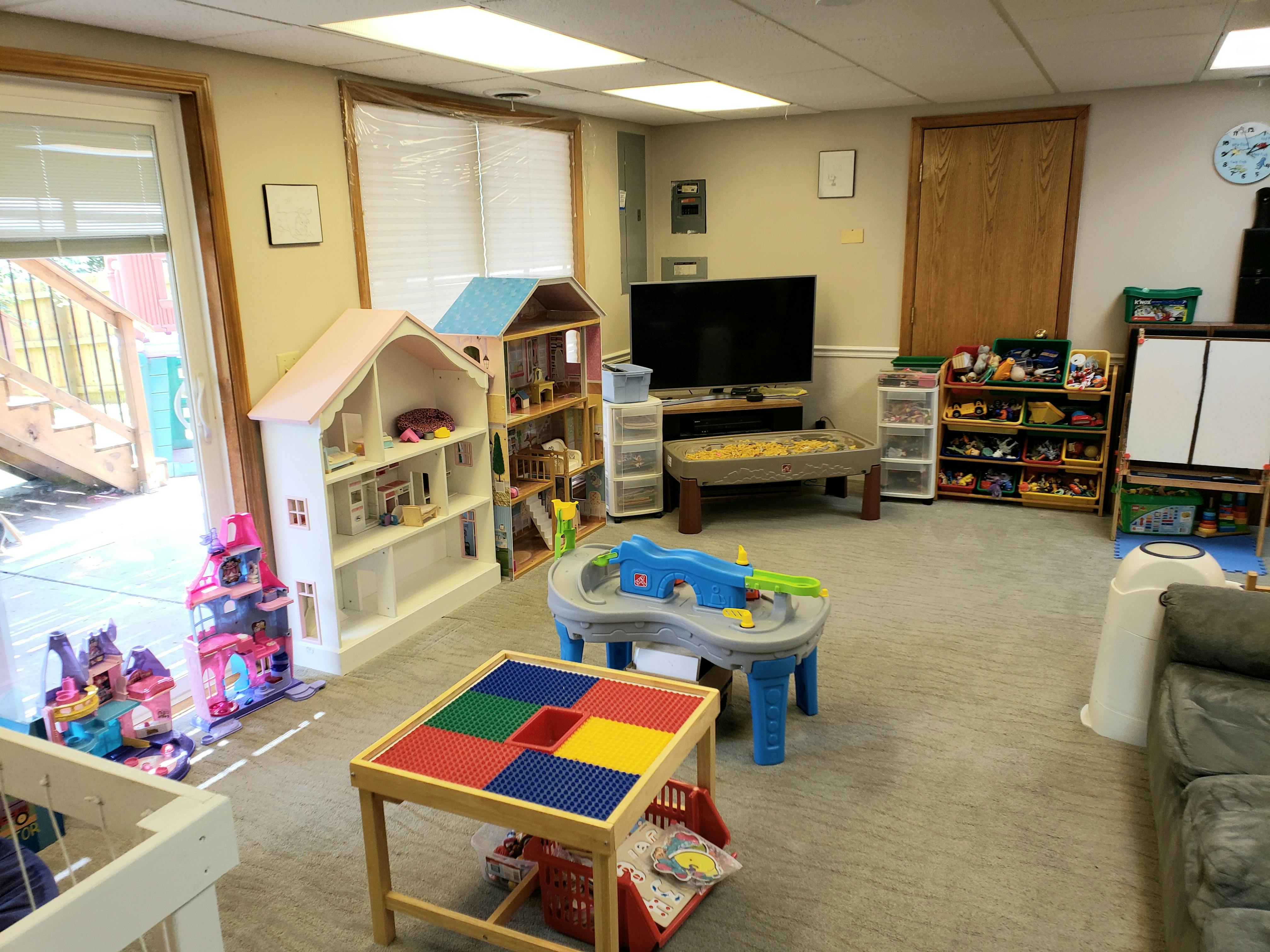 Playroom with dollhouses, toy tables, and a television
