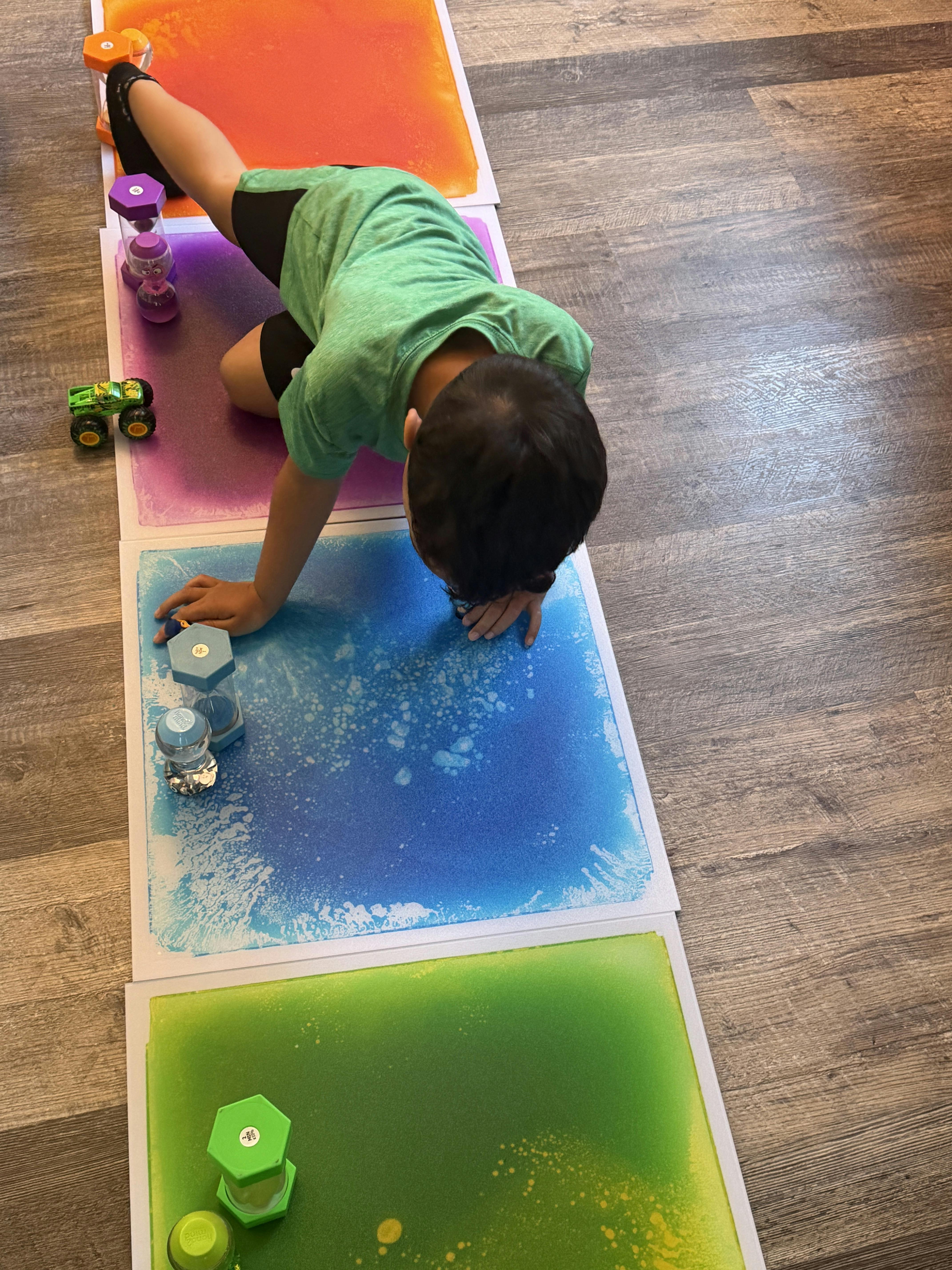 Child crawling on colorful sensory floor tiles