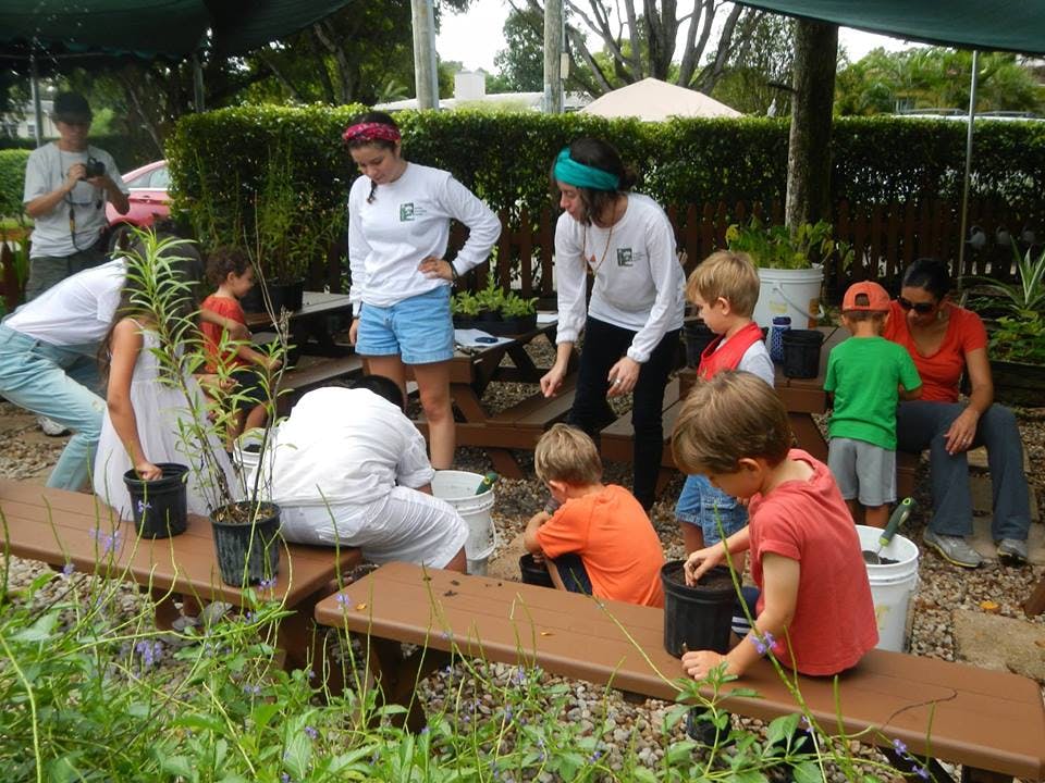Adults and children planting in a garden