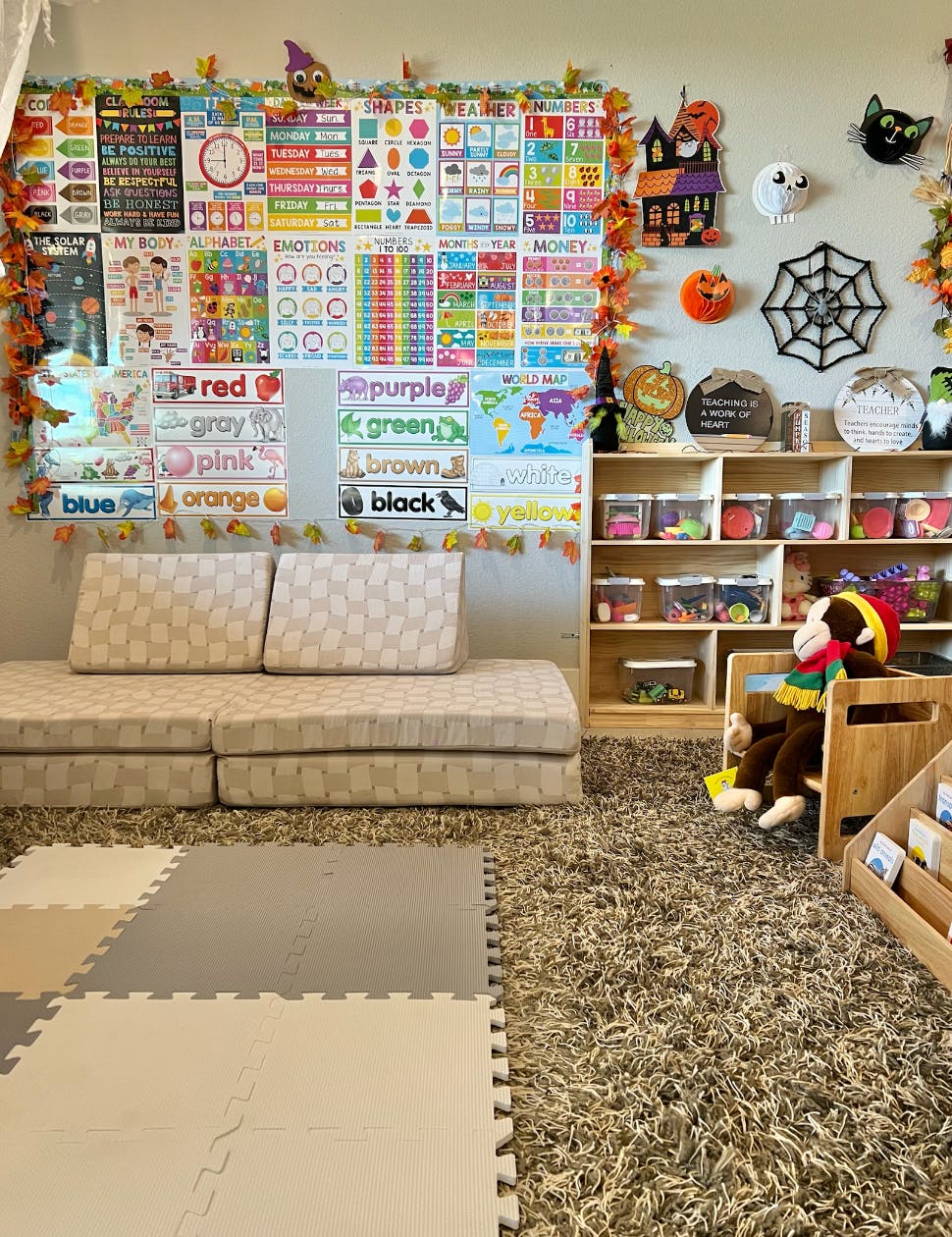 Classroom with educational posters, play mats, and a stuffed animal