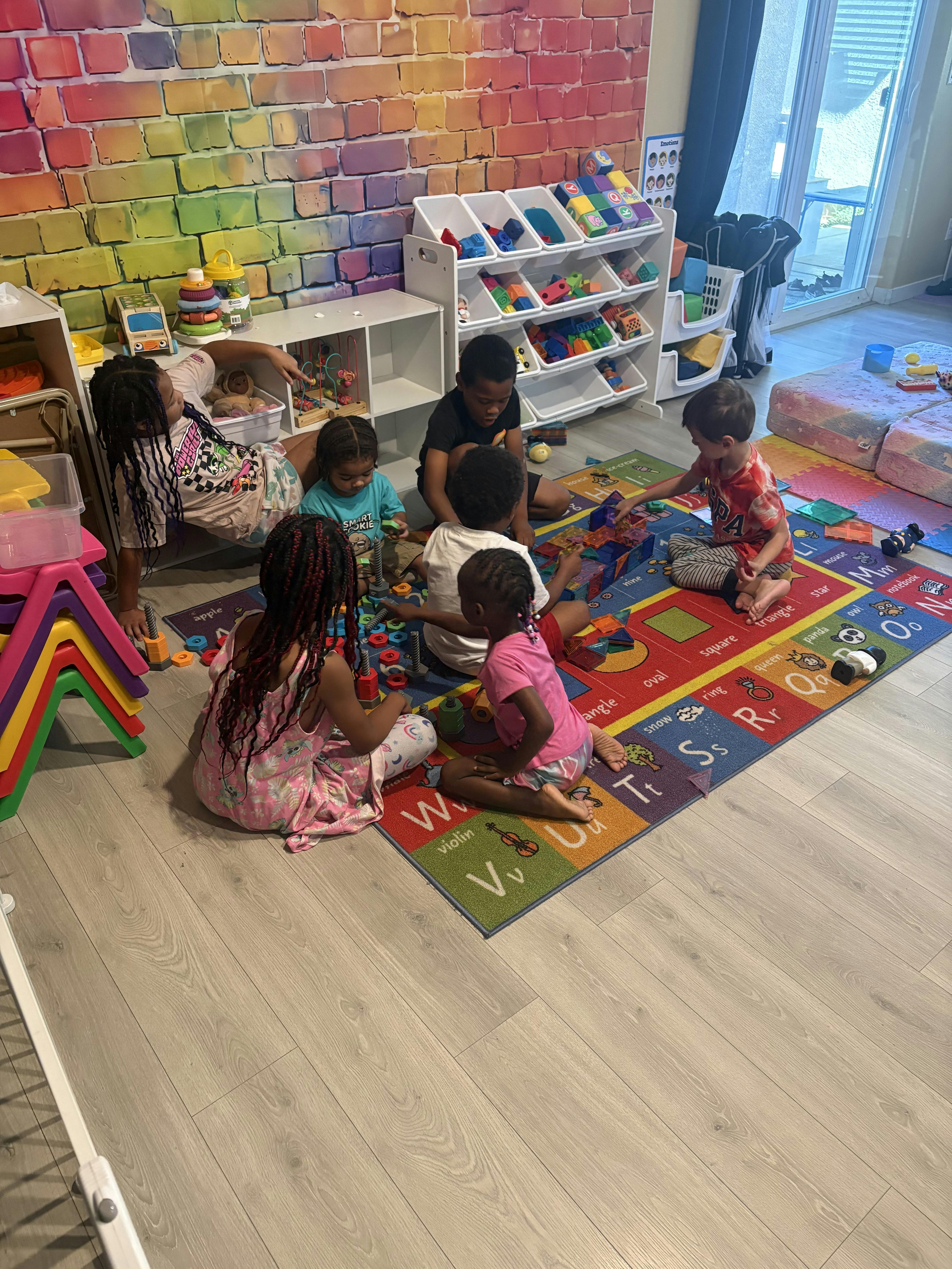 Group of children playing with building blocks on an educational rug
