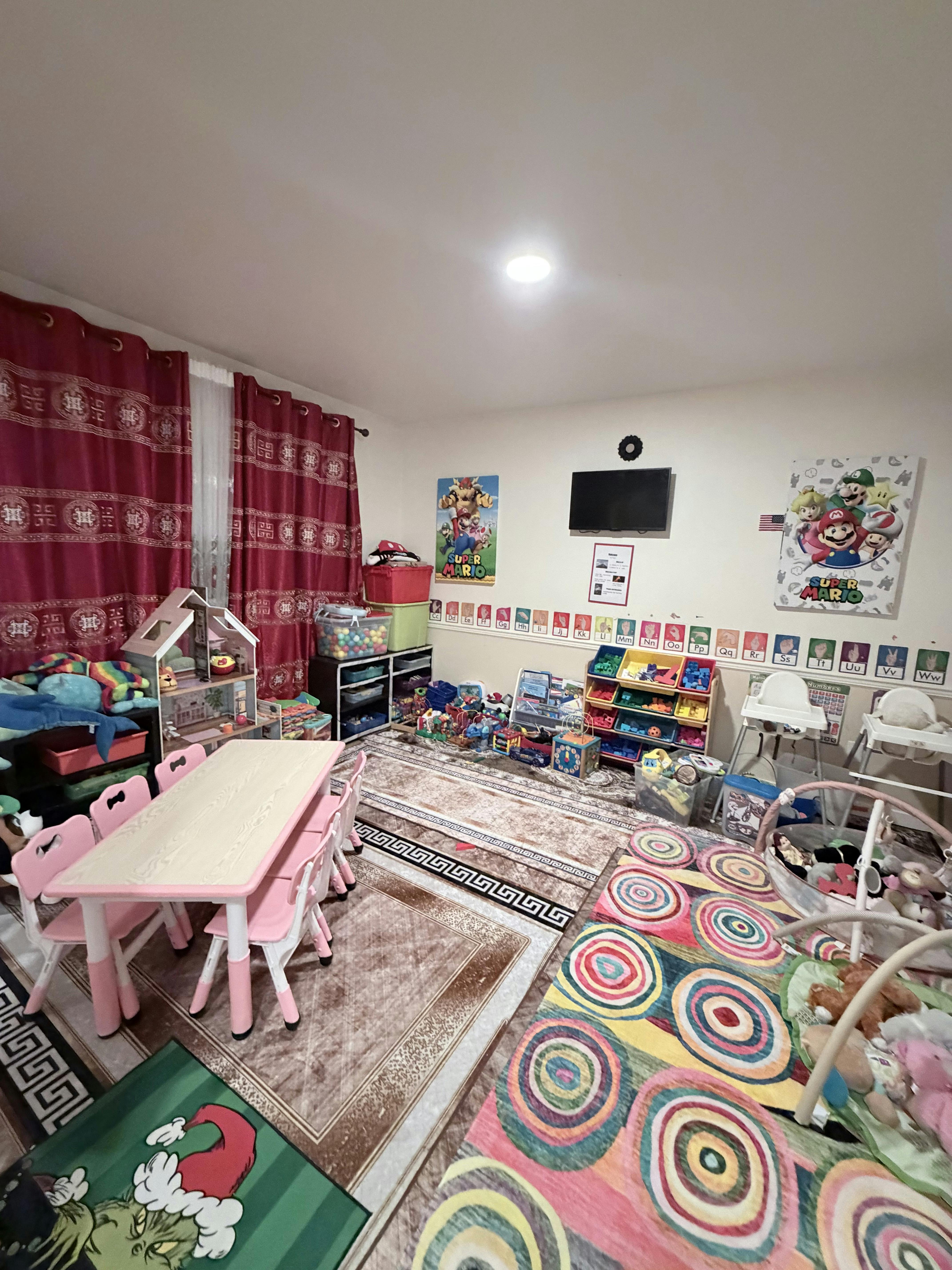 Playroom with small table and chairs, toys, and colorful rugs