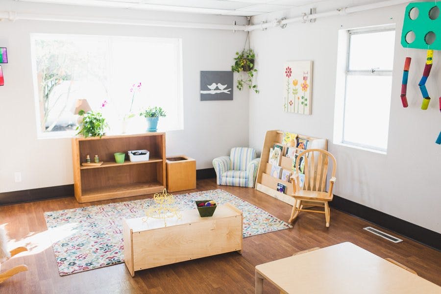 Classroom with wooden furniture, rug, and windows