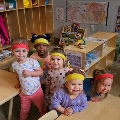 Group of children wearing colorful headbands in a classroom