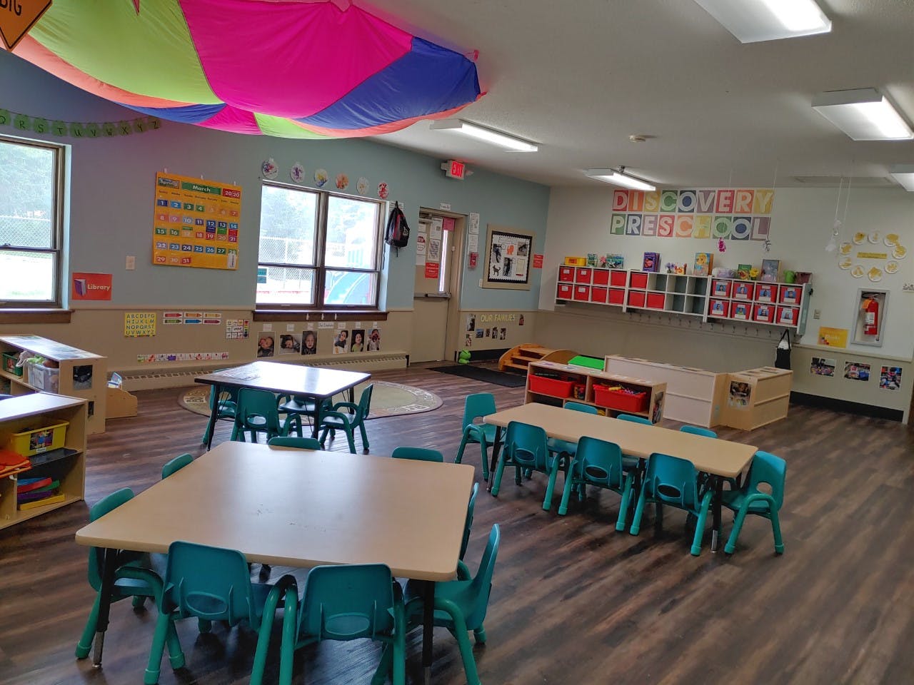 Classroom with small tables and chairs, and a Discovery Preschool sign