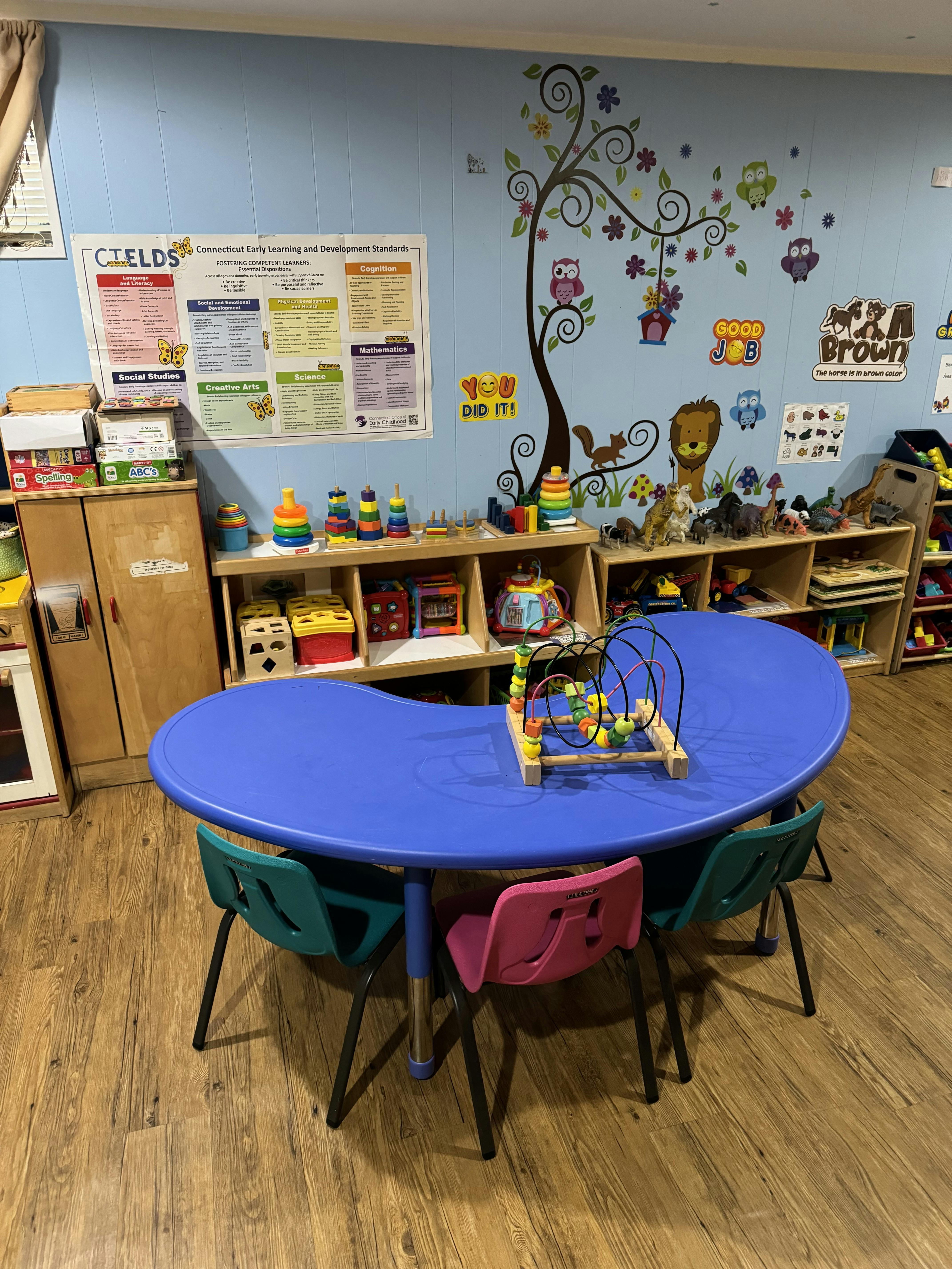 Classroom with a blue kidney-shaped table and colorful chairs