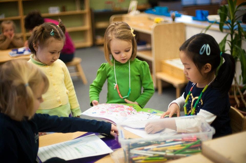 Children looking at a book in a classroom