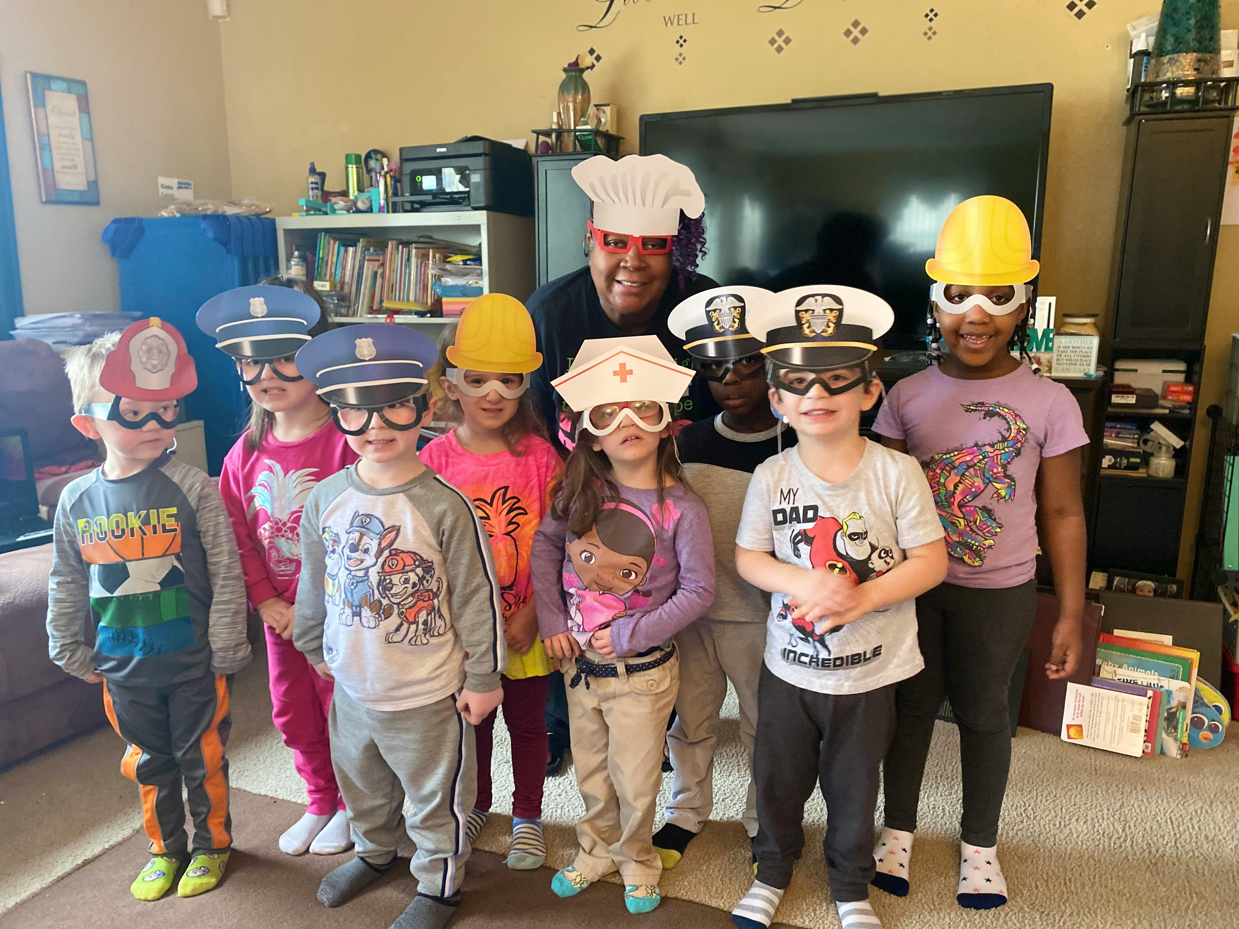 Adult and children wearing various career-themed hats and goggles