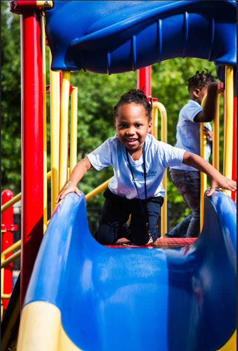 Child on a blue slide at a playground