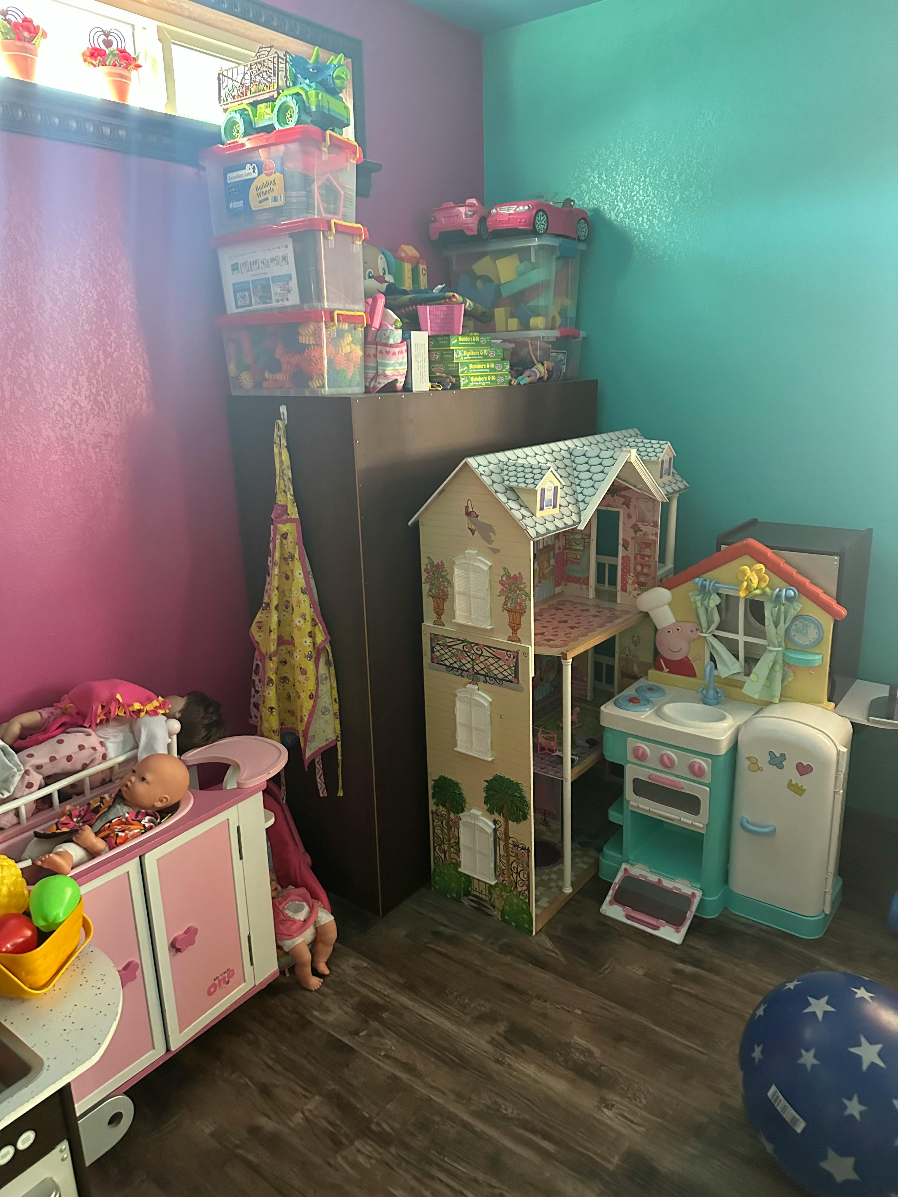 Dollhouse and toy kitchen in a room