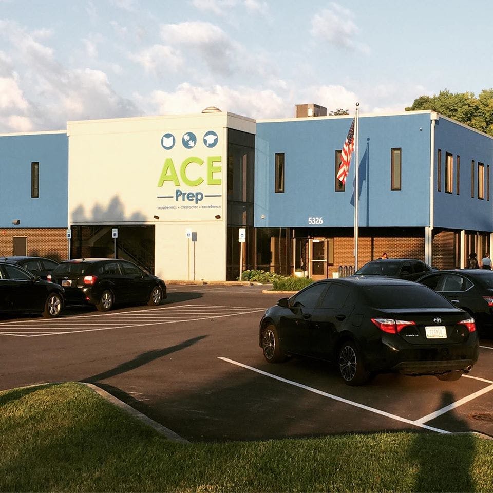 Building with "ACE Prep" sign and cars in a parking lot