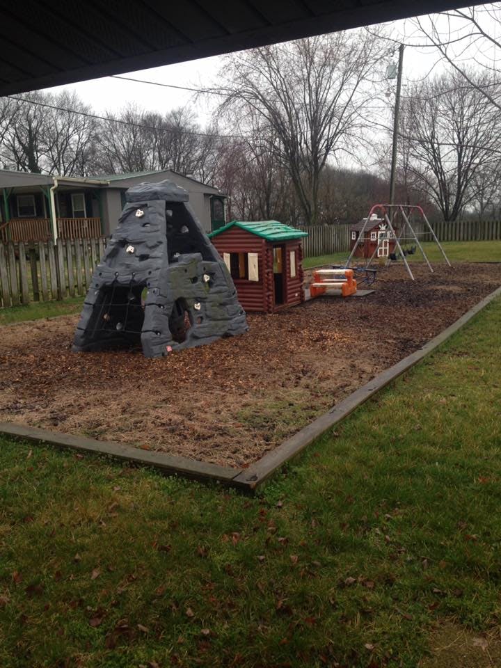 Playground with a climbing structure, playhouse, and swing set