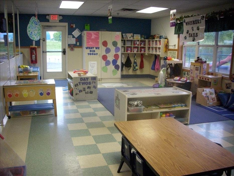Empty classroom with checkered floor, colorful decorations, and play furniture
